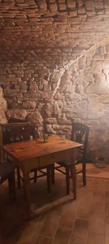 a wooden table with two chairs and a stone wall at Penzion-apartmán U Johana in Moravská Třebová