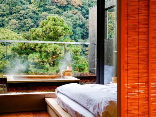 a room with a bed and a large window at Seikansou in Hakone