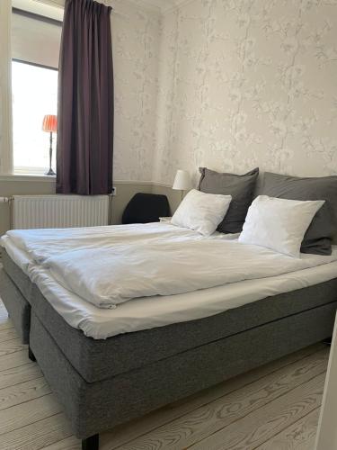 a bedroom with a large bed with white sheets at Norrfly Herrgård in Kilafors