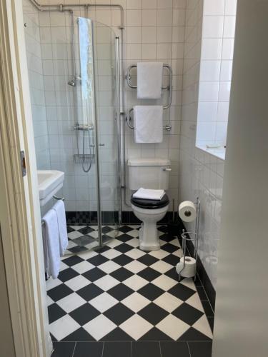 a bathroom with a black and white checkered floor at Norrfly Herrgård in Kilafors