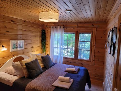 a bedroom with a bed in a log cabin at Vuokatin Aateli Herttuatar in Vuokatti