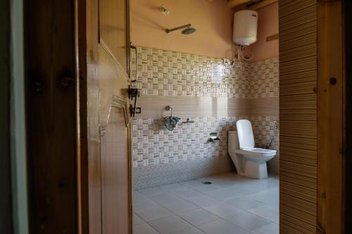 a bathroom with a toilet and a shower at Maney Homestay - Thiksey - Leh in Ranbirpura