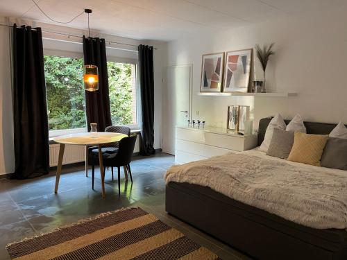 a bedroom with a bed and a table and a window at Deich Quartier 9.1 in Dorum Neufeld
