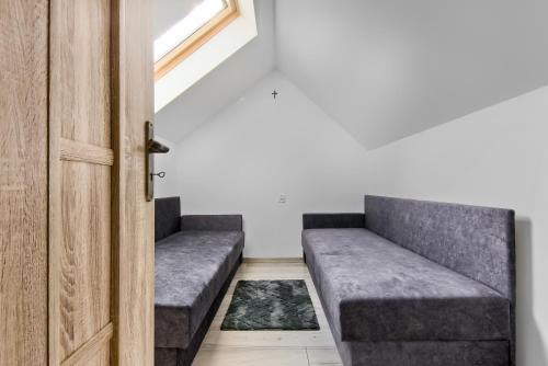 um quarto com dois sofás cinzentos ao lado de uma porta em Zielone Wzgórze em Posadowa