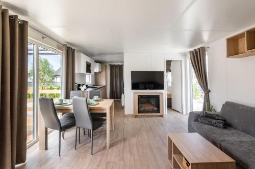 a living room with a table and a couch at Wichrowe Wzgórze Lark House in Kudowa-Zdrój