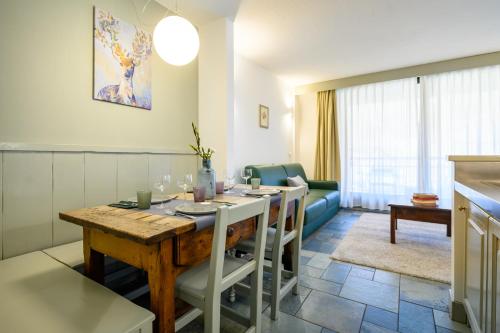 uma cozinha e sala de estar com mesa e cadeiras em Alpesmith - Bike & Ski apartments em Bardonecchia