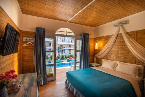 a bedroom with a bed and a balcony at Santorini Beach Resort in Gili Trawangan