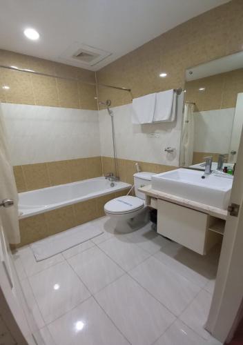 a bathroom with a tub and a toilet and a sink at Khai Hoan Apartment Hotel in Ho Chi Minh City