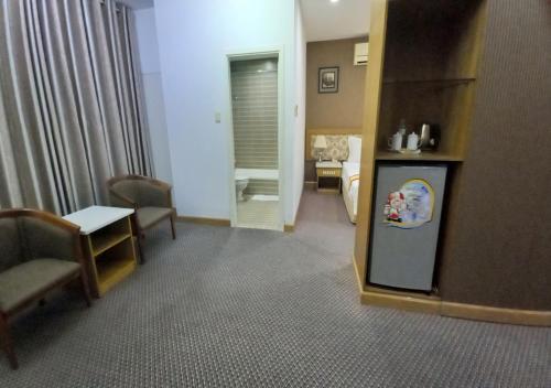 a room with a refrigerator and a table and chairs at Khai Hoan Apartment Hotel in Ho Chi Minh City