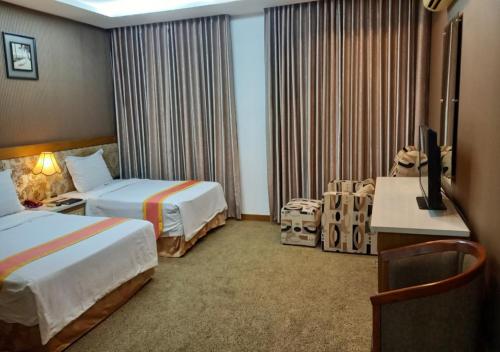 a hotel room with two beds and a television at Khai Hoan Apartment Hotel in Ho Chi Minh City