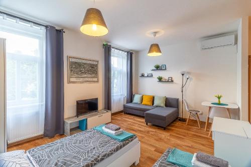 a living room with a couch and a tv at Jonas Apartments - Great Location near Bratislava City Center in Bratislava