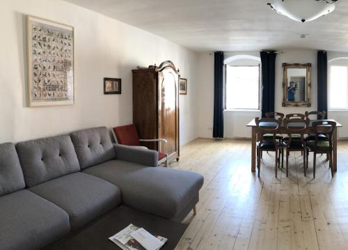 een woonkamer met een bank en een tafel en stoelen bij Blick aufs Goldene Dachl in Innsbruck