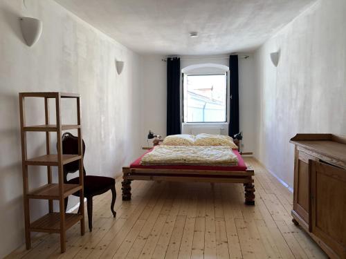 ein Schlafzimmer mit einem Bett, einer Leiter und einem Fenster in der Unterkunft Blick aufs Goldene Dachl in Innsbruck
