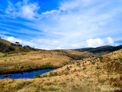 a view of a hill with a river in a field at The Grand Hotel - Heritage Grand in Nuwara Eliya