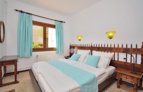 Schlafzimmer mit einem großen Bett und blauen Vorhängen in der Unterkunft Casa Esperanza 260 by Mallorca Charme in Playa de Muro
