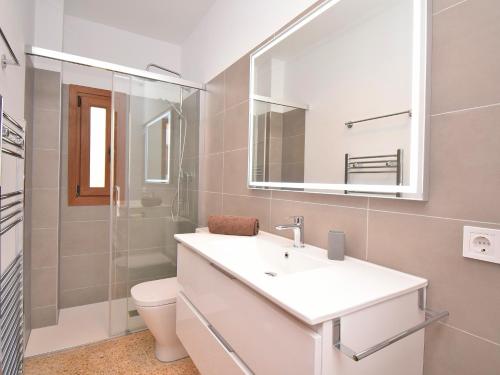 ein Badezimmer mit einem Waschbecken, einem WC und einem Spiegel in der Unterkunft Casa Esperanza 260 by Mallorca Charme in Playa de Muro
