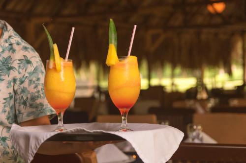 two cocktails sitting on a table in a restaurant at Cabañas Tequendama - Parque Tayrona in El Zaino