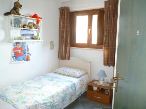 a small bedroom with a bed and a window at Attico Bellavista in Santa Maria Navarrese