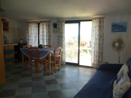 eine Küche und ein Esszimmer mit einem Tisch und Stühlen in der Unterkunft Attico Bellavista in Santa Maria Navarrese