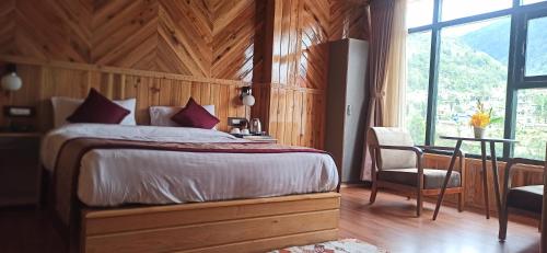 um quarto com uma cama, uma mesa e uma cadeira em Rufina Lachung Kunga em Lachung