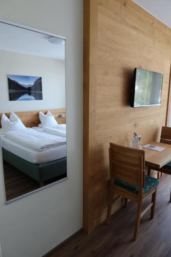 a mirror in a room with a bed and a table at Landhaus am Giessen in Vaduz