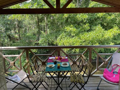 una mesa con comida y bebida en el balcón en Le Vrai Paradis, en Estréboeuf