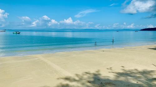 a beach with a boat in the water at Coto Center Homestay in Dao Co To