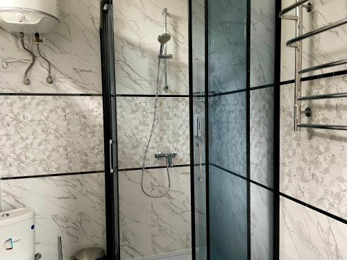 W łazience znajduje się prysznic ze szklanymi drzwiami. w obiekcie Kaufman w mieście Konopnitsa