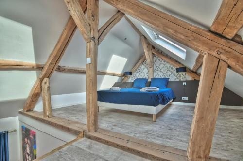 ein Schlafzimmer mit einem blauen Bett im Dachgeschoss in der Unterkunft * Le Duplex * in Maintenon