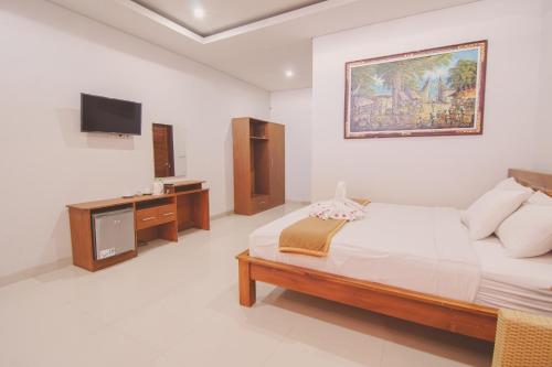 a bedroom with a bed and a television in it at caldera hotel in Kintamani