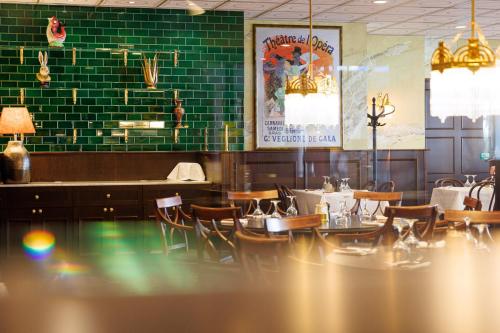 a restaurant with green brick walls and tables and chairs at ProfilHotels Hotel Garden in Malmö