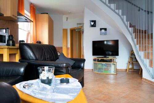 a living room with two leather chairs and a tv at Ferienhaus Strandperle in Horumersiel