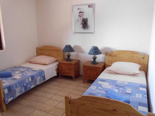 een kamer met 2 bedden en 2 nachtkastjes bij Secluded fisherman's cottage Cove Dragisina, Kornati - 12150 in Pristanišće