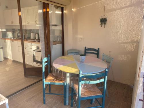 une petite cuisine avec une table et des chaises dans une pièce dans l'établissement Avignon : Appartement le in et off, à Avignon
