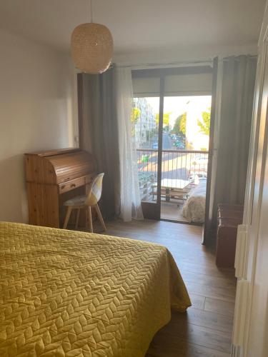 a bedroom with a bed and a desk and a window at Avignon : Appartement le in et off in Avignon