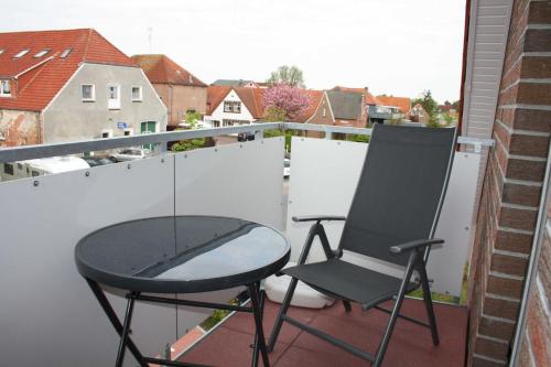 einen Stuhl und einen Tisch auf dem Balkon in der Unterkunft Ferienwohnung Perlmutt in Hooksiel