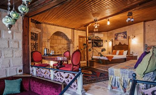 a room with a bed and a table and chairs at Larissa Cave Hotel in Nevşehir