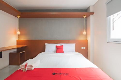 a bedroom with a large bed with a red pillow at RedDoorz Plus @ Dago Pojok 3 in Bandung