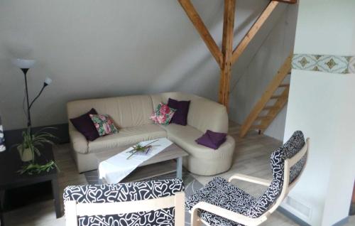 ein Wohnzimmer mit einem Sofa und 2 Stühlen in der Unterkunft Ferienwohnung Lüken in Hooksiel
