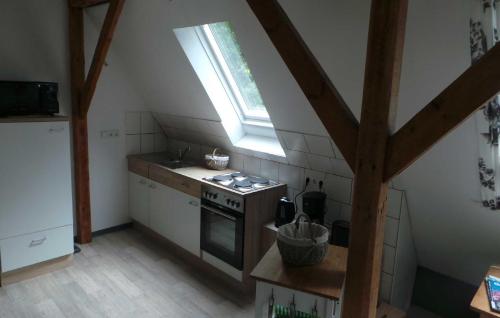 eine Küche im Dachgeschoss mit einem Herd und einem Fenster in der Unterkunft Ferienwohnung Lüken in Hooksiel