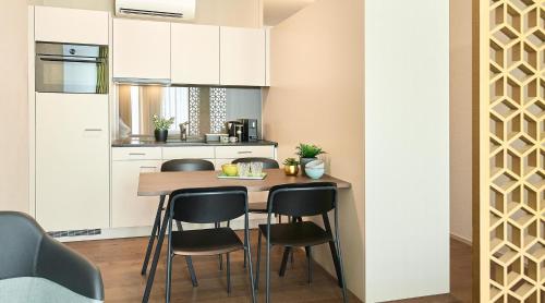 Schenkon的住宿－Lumen Apartments，一个带木桌和椅子的小厨房