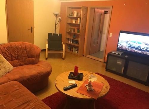 - un salon avec un canapé, une table et une télévision dans l'établissement Gemütliche 3 Raum Wohnung im Dachgeschoss, à Ehrenfriedersdorf