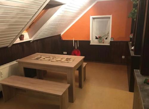 - une table et un banc dans une chambre mansardée dans l'établissement Gemütliche 3 Raum Wohnung im Dachgeschoss, à Ehrenfriedersdorf
