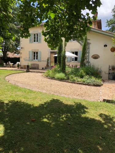 a house with a tree in front of a yard at LA PARENTHÈSE in Saubrigues