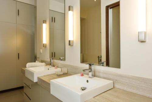 een badkamer met 2 wastafels en een grote spiegel bij Esplanade by Horizon Holidays in Tamarin