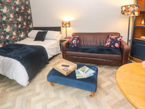 sala de estar con sofá y mesa en Peony Cottage, en St Austell