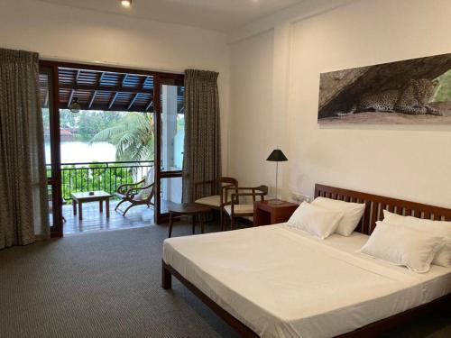 a bedroom with a bed and a balcony at Hotel Nilwala in Bentota