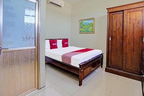 - une chambre avec un lit et des oreillers rouges dans l'établissement OYO 91587 Griya Buah De5 Syariah, à Sidoarjo
