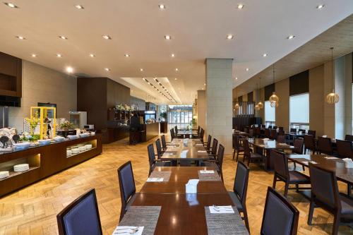 a restaurant with wooden tables and chairs and a bar at Hotel Square Ansan in Ansan