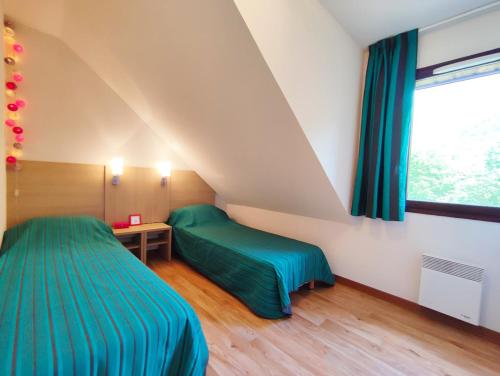 a bedroom with two beds and a window at Chez Marie-Laure, T3 résidence les Jardins de Ramel, parking, balcon, 4 personnes in Luchon